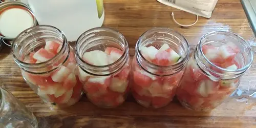 How To Pickle Watermelon Rind The Amish Way - adding the watermelon in jars