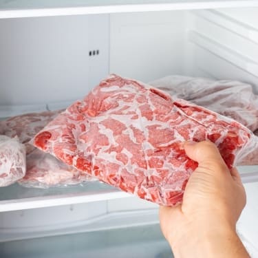 person storing meat in the freezer 