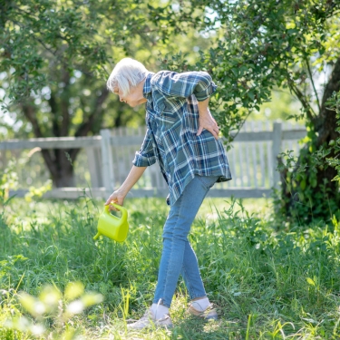 lady with backpain in the garden